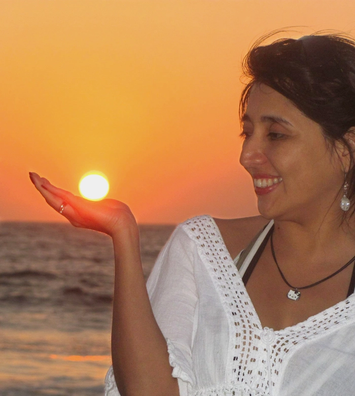 Luisa Hurtado saludando en un atardecer de luz cálida con el sol sobre su mano